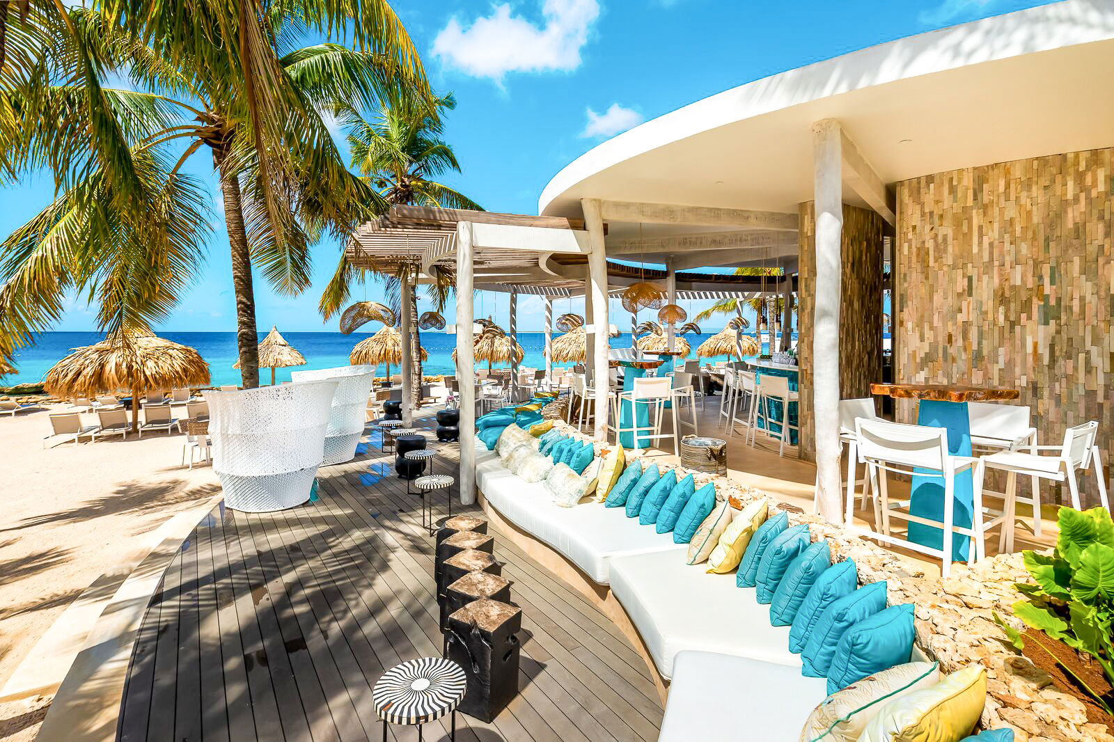 Plaza Beach & Dive Resort Bonaire beachclub met uitzicht op strand en palmbomen
